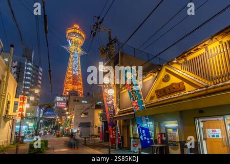 Vista della Torre Tsutenkaku e dei ristoranti con luci al neon al crepuscolo nell'area di Shinsekai, Osaka, Honshu, Giappone Foto Stock