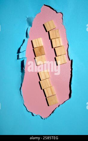 Cubetti di legno sul foro della carta strappata. Spazio copia o copia. Modello. Presentazione o pubblicità. Concetto di messaggio o comunicazione Foto Stock
