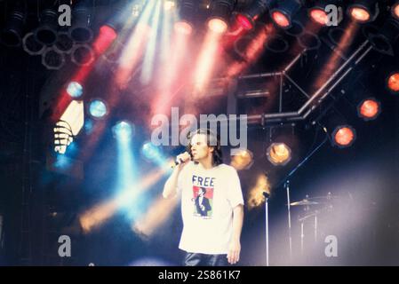 DEACON BLUE, PYRAMID STAGE, GLASTONBURY 1990: Ricky Ross di Deacon Blue sulla Pyramid Main Stage al Glastonbury Festival, Pilton Farm, Somerset, Inghilterra, 23 giugno 1990. Nel 1990 il festival ha celebrato il suo ventesimo anniversario. Foto: ROB WATKINS. I Deacon Blue sono un gruppo musicale pop-rock scozzese formatosi nel 1985, noto per le loro melodie soul e i testi introspettivi. Hanno guadagnato popolarità con successi come "Dignity" e "Real Gone Kid", diventando un atto significativo alla fine degli anni '1980 e '1990 Foto Stock