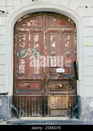 Nel cuore di Napoli, in Piazza Garibaldi, una porta in legno d'epoca è una silenziosa testimonianza dei ritmi sempre mutevoli della città. Foto Stock
