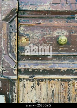 Nel cuore di Napoli, in Piazza Garibaldi, una porta in legno d'epoca è una silenziosa testimonianza dei ritmi sempre mutevoli della città. Foto Stock