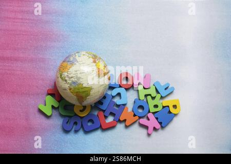 Modello globo sulle lettere colorate su uno sfondo colorato Foto Stock