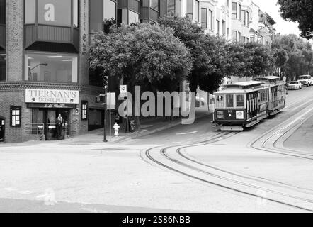 Iconica funivia di San Francisco alla base di una collina, circondata da architettura classica, a San Francisco, California, Stati Uniti. Foto Stock