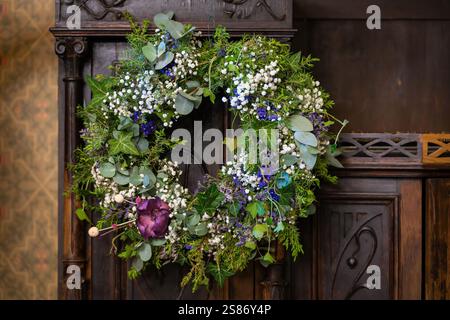 Corona della portiera anteriore. Classico eucalipto fatto a mano tutto l'anno, edera comune, ginepro e ghinepro gypsophila su fondo in legno. Foto Stock