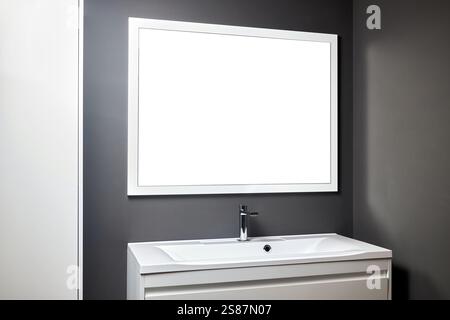 Stativo con lavandino e forniture vicino a pareti piastrellate scure in bagno con luci soffuse, crepuscolo semi scuro e specchio con mockup della cornice, spazio imitazione. Tempo Foto Stock