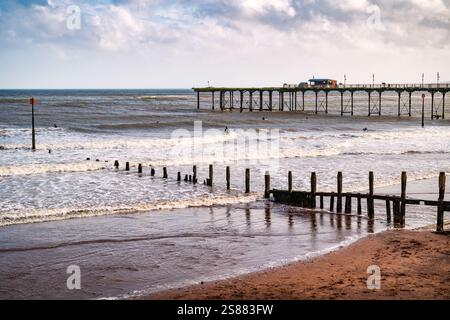 Ottobre surfisti alla spiaggia di Teignmouth e al Grand Pier, visti dalla Promenade, Teignmouth, Devon, Inghilterra, Regno Unito. Foto Stock