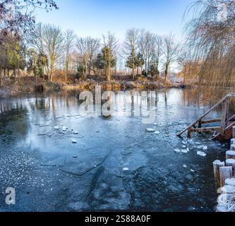 L'inverno presso la Pool Bridge Farm rivela un laghetto ghiacciato, creando un ambiente sereno per gli appassionati di nuoto all'aperto nel clima freddo dello Yorkshire. Foto Stock