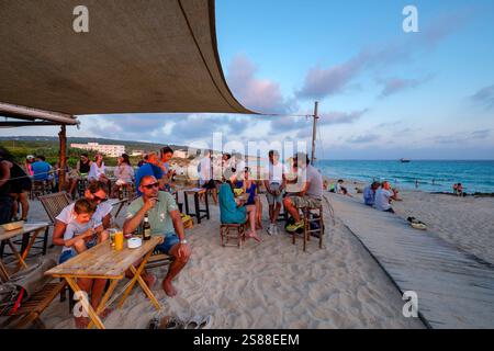 Brinda al tramonto, bar chiringuito dell'autobus El Pirata, spiaggia di Migjorn, Formentera, Isole Baleari, Spagna Foto Stock