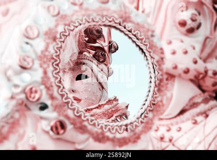 Riflesso della maschera veneziana nello specchio. Attenzione selettiva alla riflessione. Foto tonificata. Foto Stock