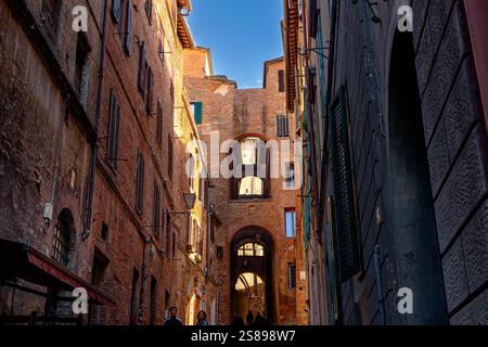 Collegando archi sopra la ripida stradina di via della Galluzza , una ripida stradina stretta con archi medievali a Siena, Italia Foto Stock