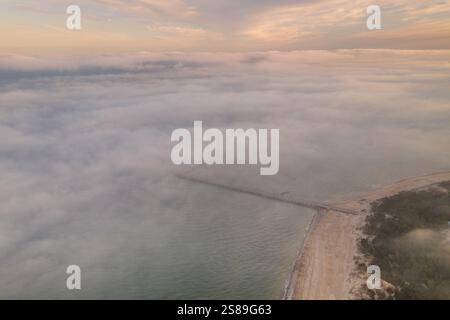 Alba sulla spiaggia della città di Palanga in Lituania. C'è un bel cielo nuvoloso e il sole sopra di esso. Colpo drone Foto Stock