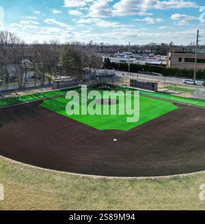 Una veduta aerea cattura un campo da baseball artificiale di prato verde luminoso con cieli limpidi sopra, mostrando nuovi terreni. Foto Stock
