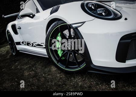 Porsche 911 GT3 RS foto a basso profilo bianca del lato di con enfasi sulla ruota anteriore e sul freno verde Foto Stock