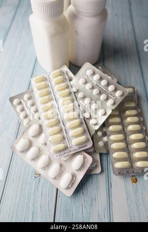 Compresse e bottiglie farmaceutiche assortite su superficie in legno Foto Stock