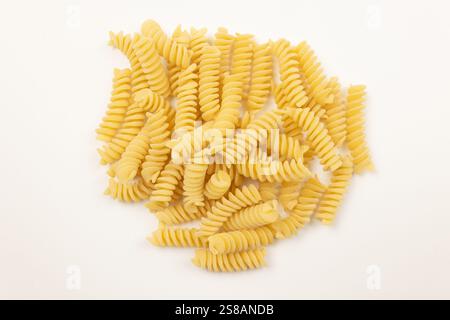 mucchio di fusilli crudi, primo piano, isolati su sfondo bianco Foto Stock