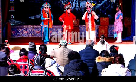 Zhangye, Cina. 22 gennaio 2025. I fan del patrimonio culturale immateriale eseguono l'opera Qin per turisti nella piazza culturale del villaggio di Zhenjiang, città di Heiquan, contea di Gaotai, a Zhangye, Cina, il 21 gennaio 2025. (Foto di Costfoto/NurPhoto) credito: NurPhoto SRL/Alamy Live News Foto Stock
