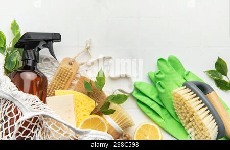 Prodotti e utensili per la pulizia naturali disposti su una superficie bianca, che enfatizzano i metodi di pulizia eco-compatibili Foto Stock