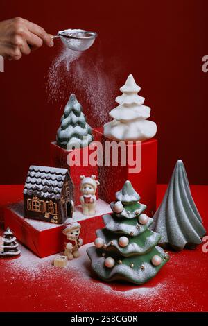 Sfondo natalizio con scatole regalo e colorate figure di cioccolato con alberi di Natale, orsi e palle. Sfondo rosso Foto Stock