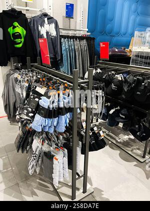Kiev, Ucraina - 21 gennaio 2025: Un negozio al dettaglio propone articoli di abbigliamento, accessori e cappelli organizzati su scaffali all'interno di un interno moderno. In mostra Foto Stock