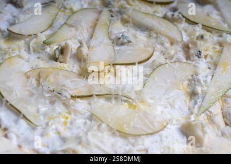 Fondo testurizzato per pizza con pera, gorgonzola e parmigiano. Pizza cruda in un piano riccio. Foto di alta qualità Foto Stock