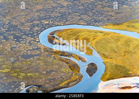 Vista aerea che mostra i tortuosi fiumi islandesi che attraversano il vivace terreno muschiato. Il paesaggio rivela trame e motivi intricati, creando Foto Stock