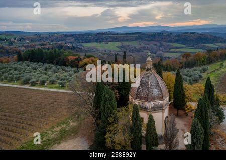 Vista aerea della Cappella di San Michele Arcangelo a Semifonte, in Toscana, circondata da dolci colline, oliveti, vigneti e cipressi Foto Stock