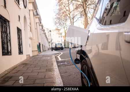 Auto elettrica collegata e cambiabile in città strada Foto Stock