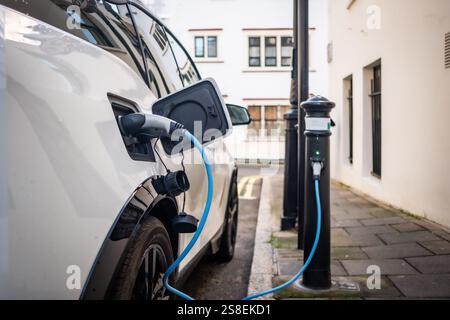 Auto elettrica collegata e cambiabile in città strada Foto Stock