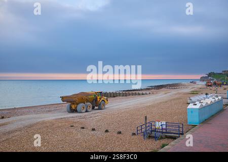 Eastbourne, East Sussex, Regno Unito - 20 gennaio 2025. Un dumper articolato Volvo A30G su una spiaggia di ciottoli contro un cielo grigio e un mare blu. Foto Stock