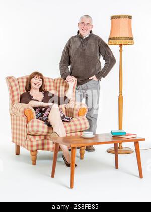 Coppia rilassata. Una scena domestica retrò con una rilassata coppia britannica seduta nella loro confortevole, se antiquata, casa. Foto Stock
