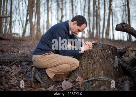 Uomo nel bosco che prega Foto Stock