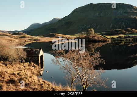 Una casa di barche si trova sul bordo dei laghi Cregennan, o Llynnau Cregennan, vicino ad Arthog, Dolgellau nel Galles del Nord con Cadair Idris sullo sfondo Foto Stock