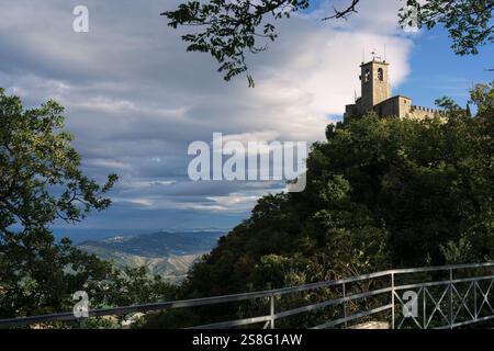 Antico castello in pietra su una collina circondata da alberi verdi a San Marino Foto Stock
