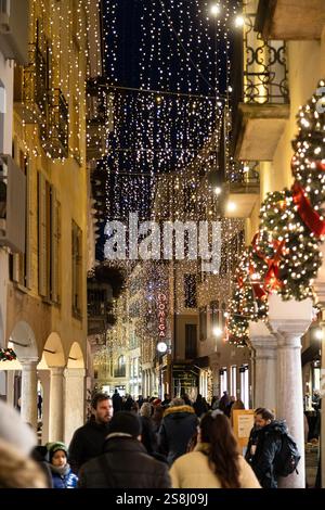 Lugano, Svizzera - 22 dicembre 2024: Una strada con luci natalizie e decorazioni natalizie, con gente che si gode la notte Foto Stock