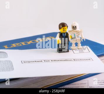 Chappaqua, NY - 11 aprile 2024: LEGO minifigures ragioniere e scheletro illustrazione umoristica di dire, nulla è certo tranne morte e tasse. Foto Stock
