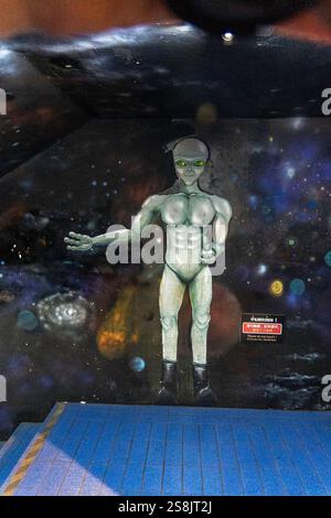 Krabi, tailandia - 24 dicembre 2024: Murale di una figura aliena dipinta su un muro in un luogo sotterraneo che mostra cosmico Foto Stock