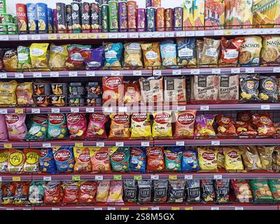 Ampia scelta di snack fritti sugli scaffali dei supermercati con confezioni colorate. Foto Stock