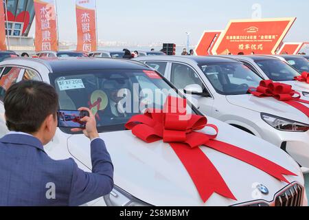 YANTAI, CINA - 23 GENNAIO 2025 - i dipendenti premiati posano per una foto con la vettura premiata durante la cerimonia di premiazione del gruppo Jierui 2024 'Go Foto Stock