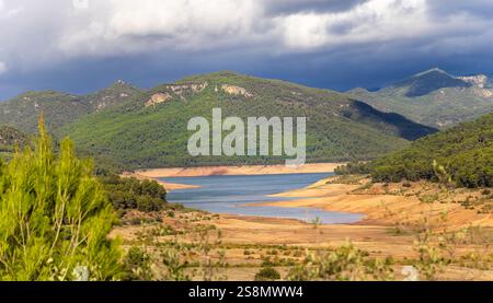 Una splendida catena montuosa con un fiume che la attraversa. Il cielo è nuvoloso, donando alla scena un'atmosfera tranquilla e tranquilla Foto Stock