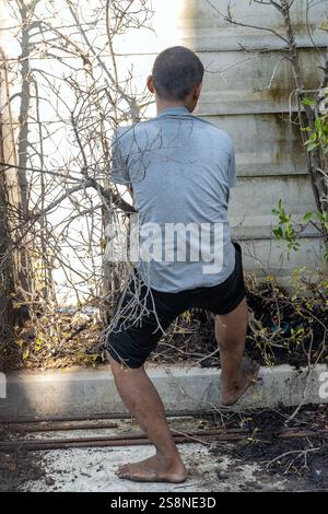 SAMUT PRAKAN, THAILANDIA, ottobre 03 2024, Un uomo scalzo cerca di tirare fuori un albero dal suolo Foto Stock
