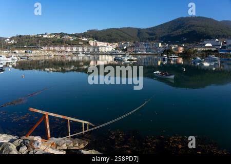 VIVEIRO, SPAGNA - 17 DICEMBRE 2021: Vista del bellissimo villaggio di Viveiro riflessa sull'estuario in una giornata di sole, provincia di Lugo, Galizia, Spagna. Foto Stock