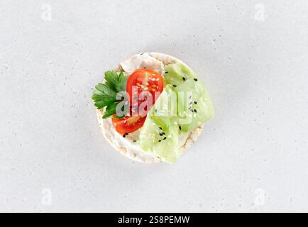 Torte di riso o panini con verdure fresche e formaggio spalmabile su sfondo bianco. Spuntini a basso contenuto calorico e senza glutine Foto Stock
