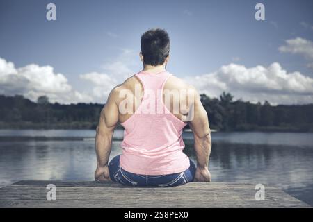 Giovane uomo sportivo muscoloso sul retro del lago Foto Stock
