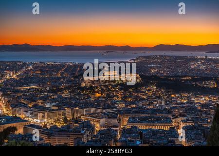 Ammira lo skyline illuminato di Atene, Grecia, con il Tempio del Partenone e l'Acropoli al tramonto Foto Stock