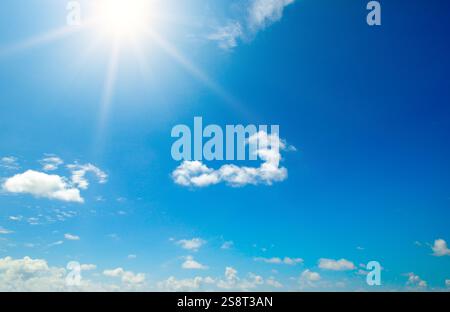 Couds nel cielo blu. Il luminoso sole di mezzogiorno illumina lo spazio. Foto Stock