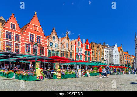 Bruges, Belgio, 5 luglio 2023: Case cittadine in stile tradizionale fiammingo-barocco edifici colorati con facciate colorate, ristoranti di strada e caffè terrazzato Foto Stock