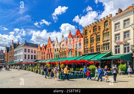 Bruges, Belgio, 5 luglio 2023: Case cittadine in stile barocco-fiammingo, edifici colorati con facciate colorate, ristoranti di strada e caffè terrazzato Foto Stock