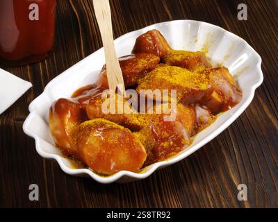 Salsiccia al curry con salsa Foto Stock
