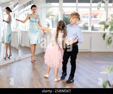 Ballerini Tween, ragazza e ragazzo che praticano il valzer in uno studio di danza Foto Stock