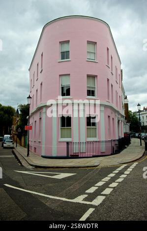 Vivace edificio d'angolo rosa e bianco a Londra, che mostra una giocosa architettura in stile georgiano e un tocco di creatività urbana Foto Stock
